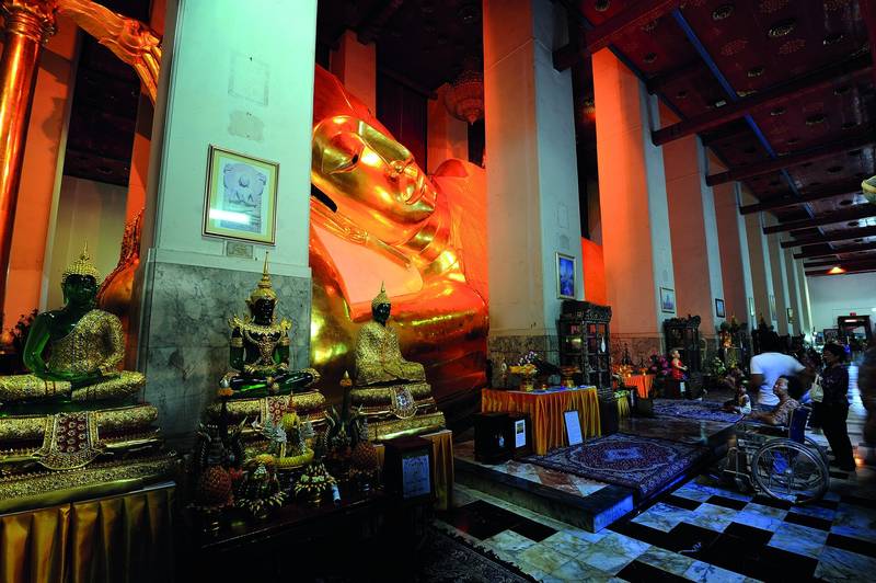 องค์พระนอนปิดทองขนาดใหญ่ ทอดยาวอยู่ในวิหารที่มีเสาเรียงเป็นแถว